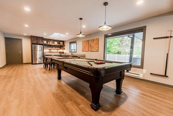 a game room with a pool table and a bar